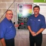 2 men in blue shirts smiling