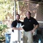 Man in apron shaking another man's hand