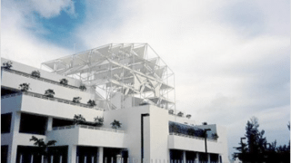 large white building with truss structure on roof