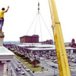 crane lifting truss structure to worker on building