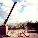 Trusses being lifted by crane with workers