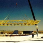 yellow truss on crane with men standing by