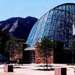 Glass walled building set against mountain view
