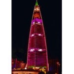 tall building lit up pink at night
