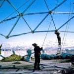 2 men building trusses outside