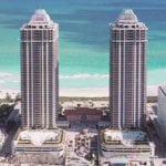 2 tall buildings in front of beach