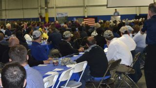 speaker presenting to a large group seated at tables